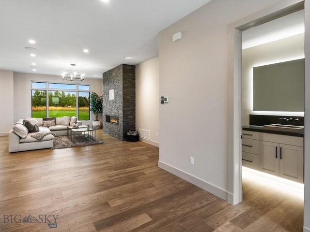 20 Bold Driver Ln, Bozeman, MT 59718 - living area with wood finished floors, baseboards, a chandelier, recessed lighting, and a stone fireplace