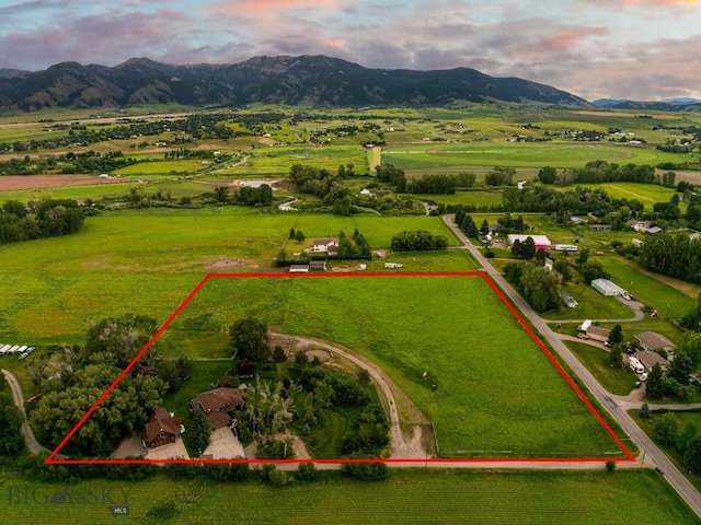 aerial view at dusk with a mountain view and a rural view