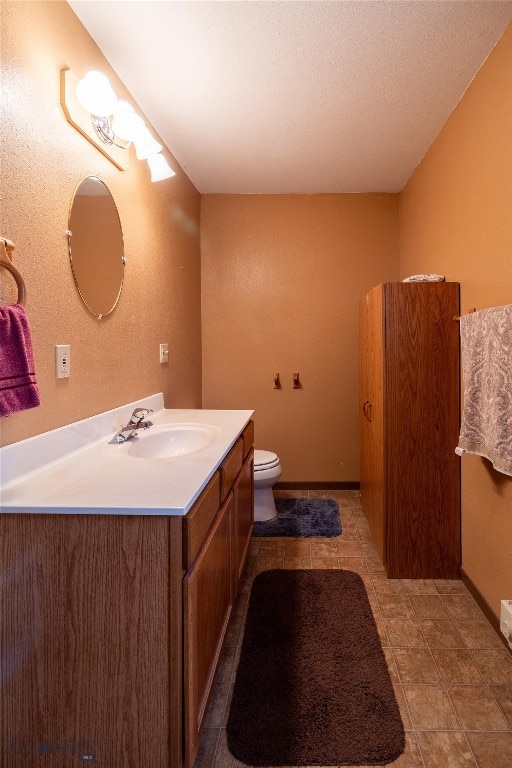 bathroom featuring tile patterned floors, vanity, and toilet