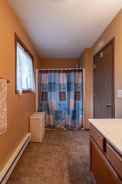 bathroom with tile patterned flooring, vanity, and a baseboard radiator