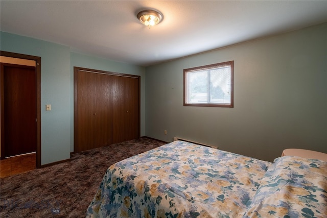 carpeted bedroom featuring baseboard heating and a closet