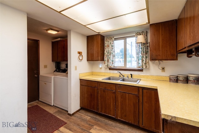 kitchen with sink, hardwood / wood-style flooring, and independent washer and dryer