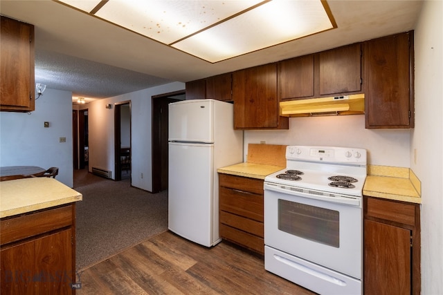 kitchen with a baseboard heating unit, dark carpet, and white appliances