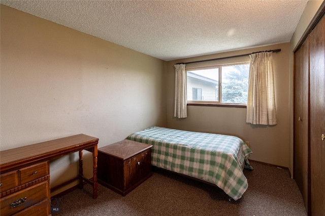 carpeted bedroom with a textured ceiling and a closet