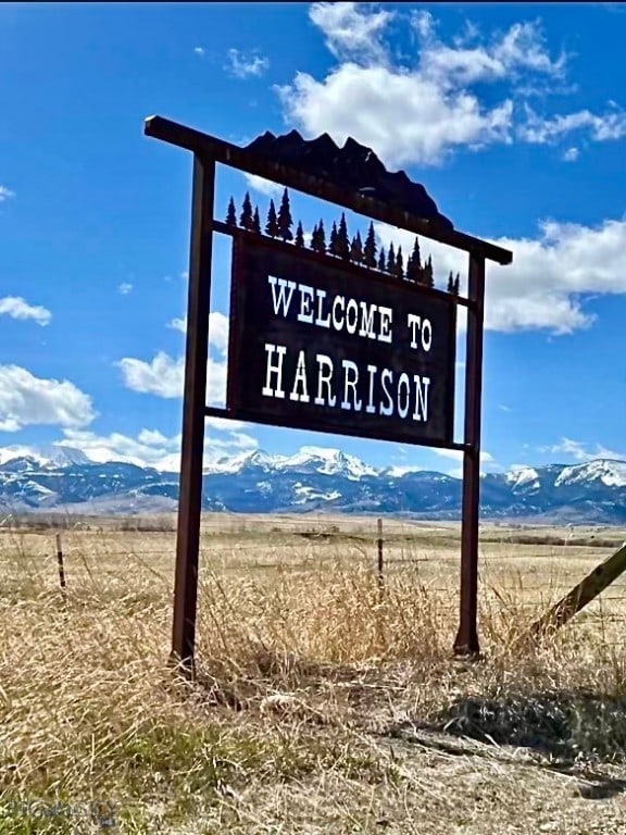 community sign featuring a mountain view and a rural view