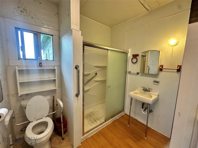 bathroom with hardwood / wood-style flooring, toilet, an enclosed shower, and sink