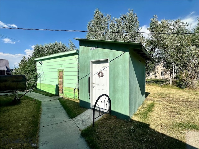 view of outbuilding featuring a yard