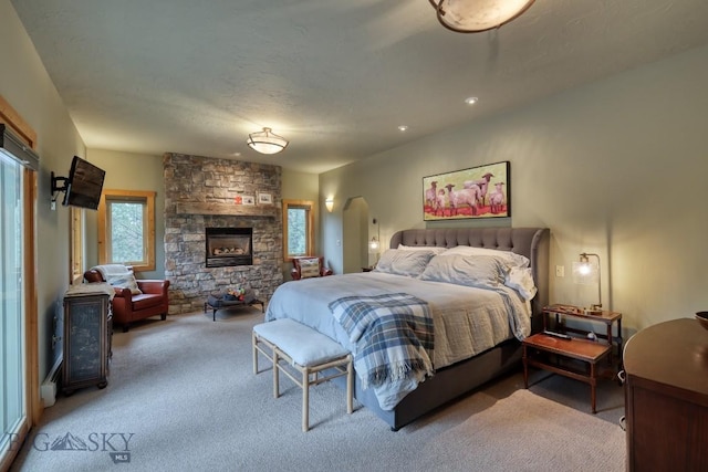 83 W Pine Cone Ter, Big Sky, MT 59716 - bedroom featuring carpet floors and a stone fireplace