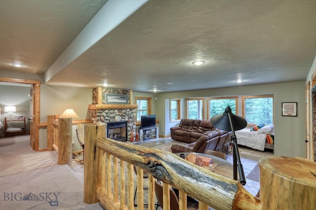 83 W Pine Cone Ter, Big Sky, MT 59716 - living area featuring a stone fireplace, light carpet, recessed lighting, a textured ceiling, and baseboards