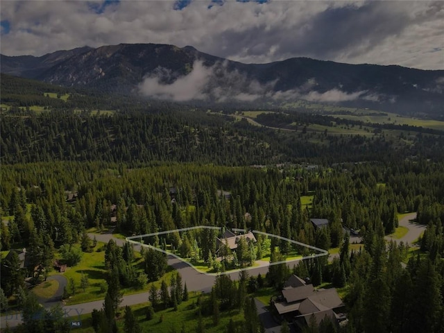 83 W Pine Cone Ter, Big Sky, MT 59716 - aerial view of property and surrounding area featuring a forest, a mountainous background, and property parcel outlined