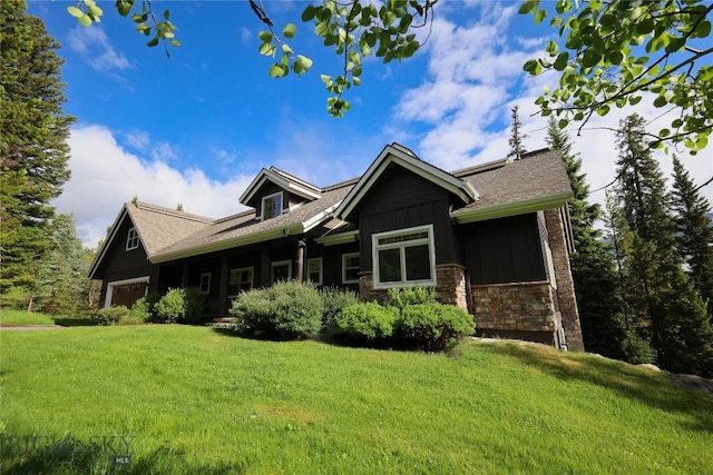 83 W Pine Cone Ter, Big Sky, MT 59716 - view of front of home featuring a front lawn, board and batten siding, a garage, and stone siding