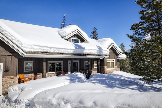 83 W Pine Cone Ter, Big Sky, MT 59716 - view of front of home with board and batten siding, stone siding, and a porch