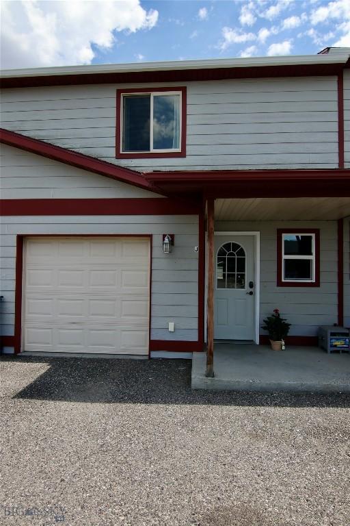 view of front of home featuring a garage, covered porch, and driveway