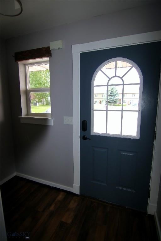 foyer featuring baseboards and dark wood finished floors