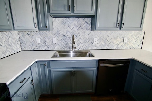 kitchen featuring tasteful backsplash, light countertops, a sink, and dishwashing machine