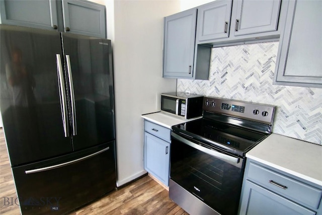 kitchen featuring light countertops, stainless steel appliances, backsplash, and gray cabinetry