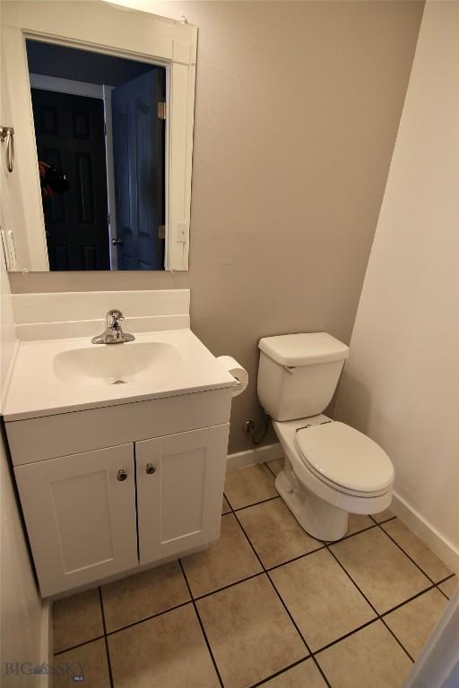 bathroom featuring baseboards, vanity, toilet, and tile patterned floors