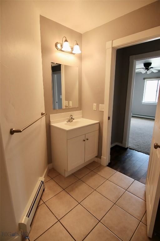 bathroom with ceiling fan, vanity, baseboard heating, and tile patterned floors