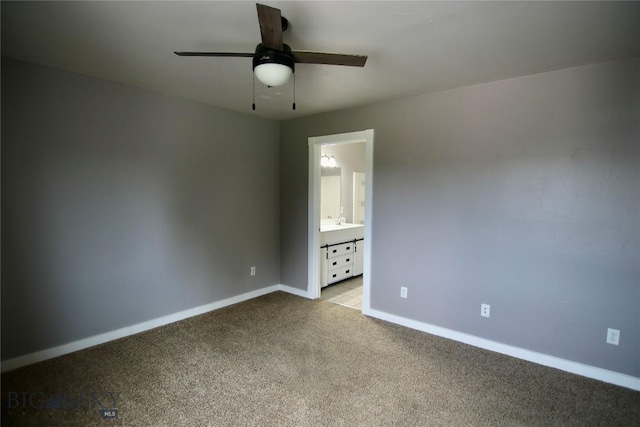 unfurnished bedroom with carpet floors, ensuite bath, a ceiling fan, and baseboards