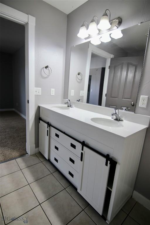 full bath with double vanity, a sink, and tile patterned floors