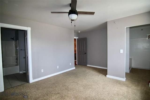 unfurnished bedroom with a baseboard heating unit, baseboards, carpet flooring, and ensuite bathroom