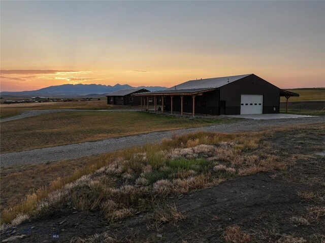 view of front of house featuring a mountain view, a garage, and a lawn