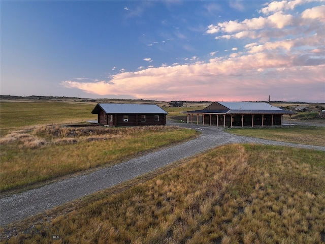 view of front of property with an outdoor structure and a rural view