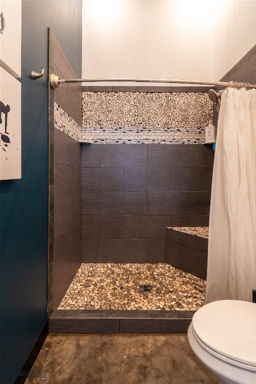 bathroom featuring curtained shower and toilet