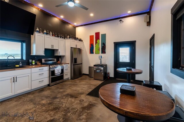 kitchen featuring white cabinetry, butcher block counters, sink, ceiling fan, and appliances with stainless steel finishes