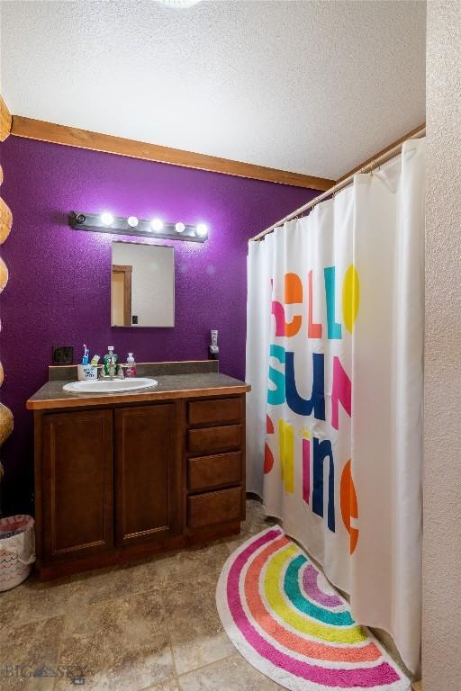 bathroom featuring a shower with shower curtain, vanity, and a textured ceiling