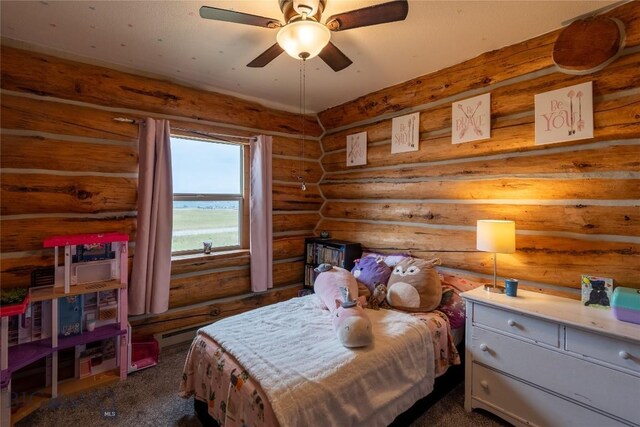 bedroom with dark carpet and log walls