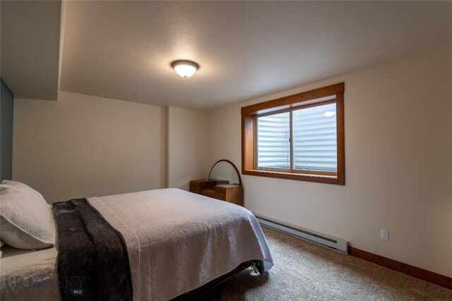 carpeted bedroom with a baseboard heating unit