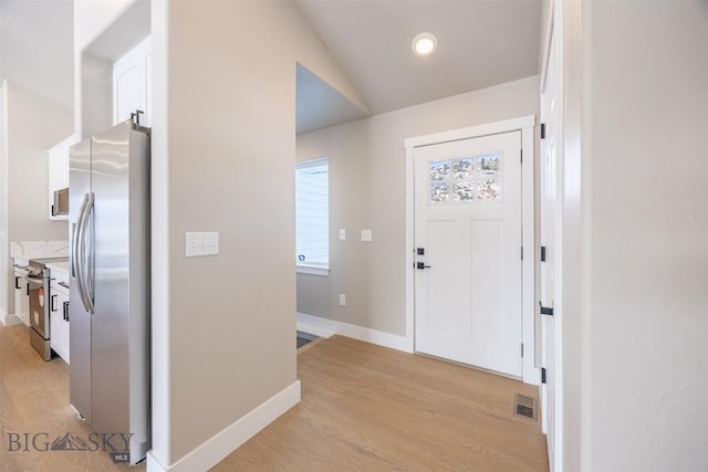 foyer entrance featuring light hardwood / wood-style floors and lofted ceiling