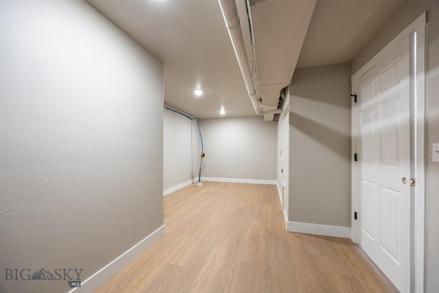 basement with light hardwood / wood-style flooring