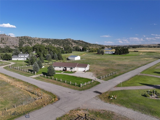 view of property's community featuring a rural view, a mountain view, and a lawn