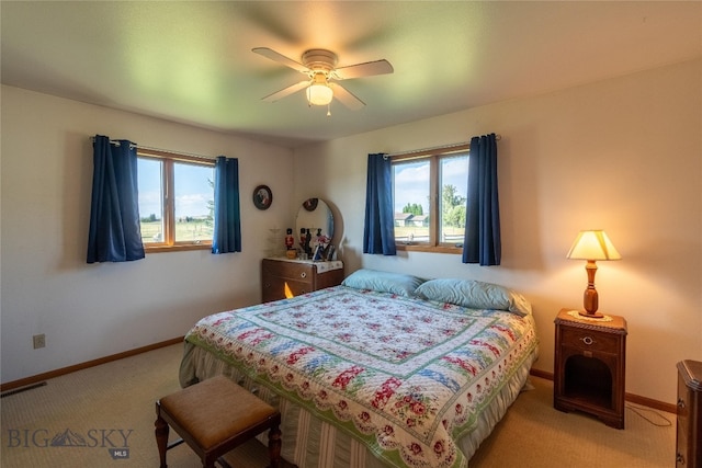 carpeted bedroom with multiple windows and ceiling fan