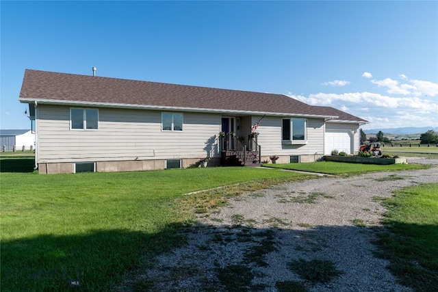 back of property featuring a garage and a lawn