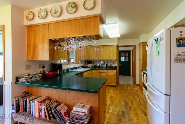 kitchen featuring kitchen peninsula, light hardwood / wood-style floors, sink, and white refrigerator