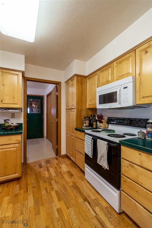 kitchen featuring white appliances, light brown cabinets, and light hardwood / wood-style flooring