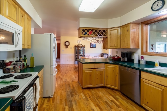 kitchen featuring sink, kitchen peninsula, light hardwood / wood-style flooring, and white appliances