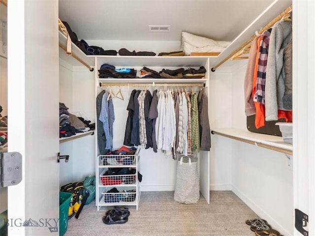 walk in closet featuring visible vents and carpet