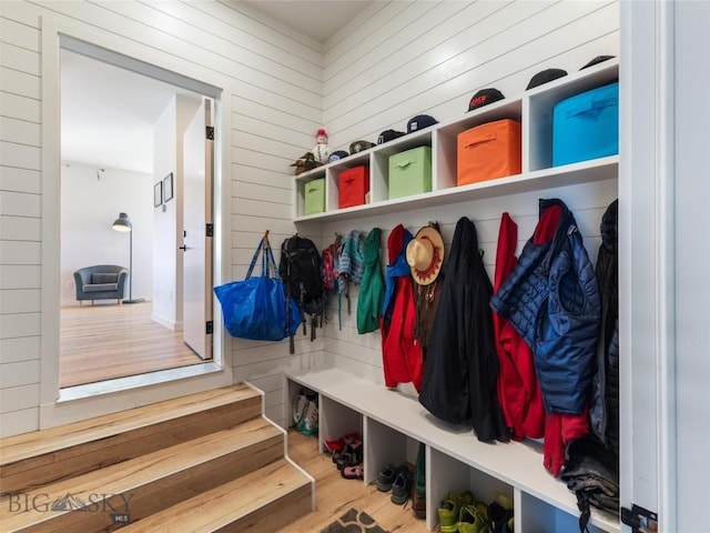 mudroom featuring wood finished floors and wood walls