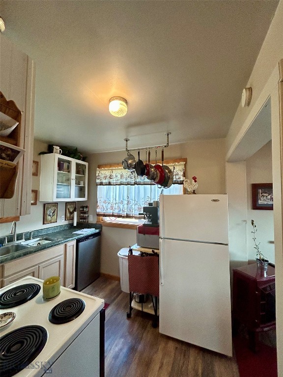 kitchen with hardwood / wood-style floors, range, white fridge, stainless steel dishwasher, and white cabinets