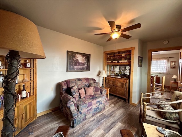 living room with dark hardwood / wood-style flooring and ceiling fan