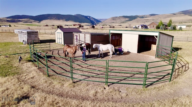 exterior space with a rural view, a mountain view, and a storage unit