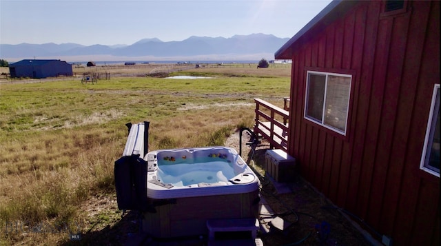 exterior space with a rural view, a mountain view, and a hot tub