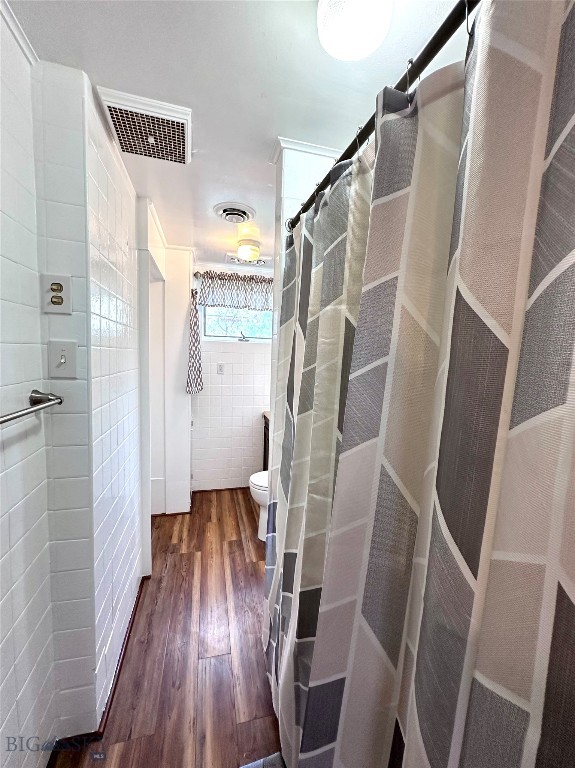 bathroom featuring a shower with curtain, toilet, tile walls, and hardwood / wood-style flooring