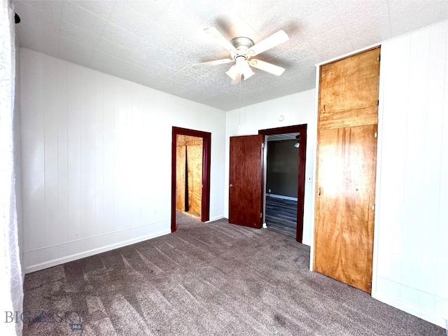 unfurnished bedroom featuring dark colored carpet and ceiling fan