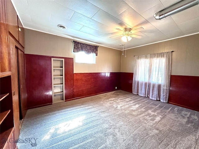 carpeted empty room featuring ceiling fan and ornamental molding