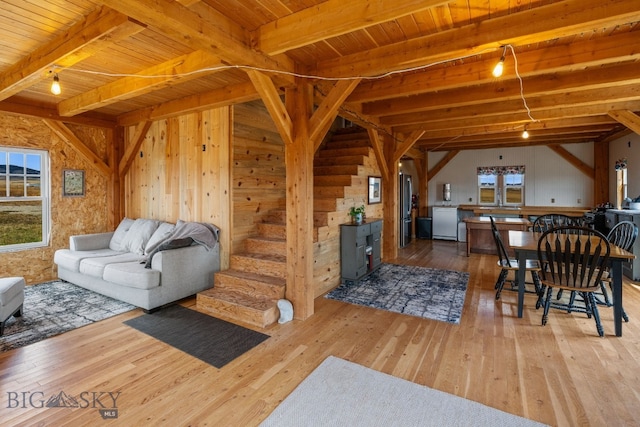 living room featuring light hardwood / wood-style floors, beam ceiling, and plenty of natural light